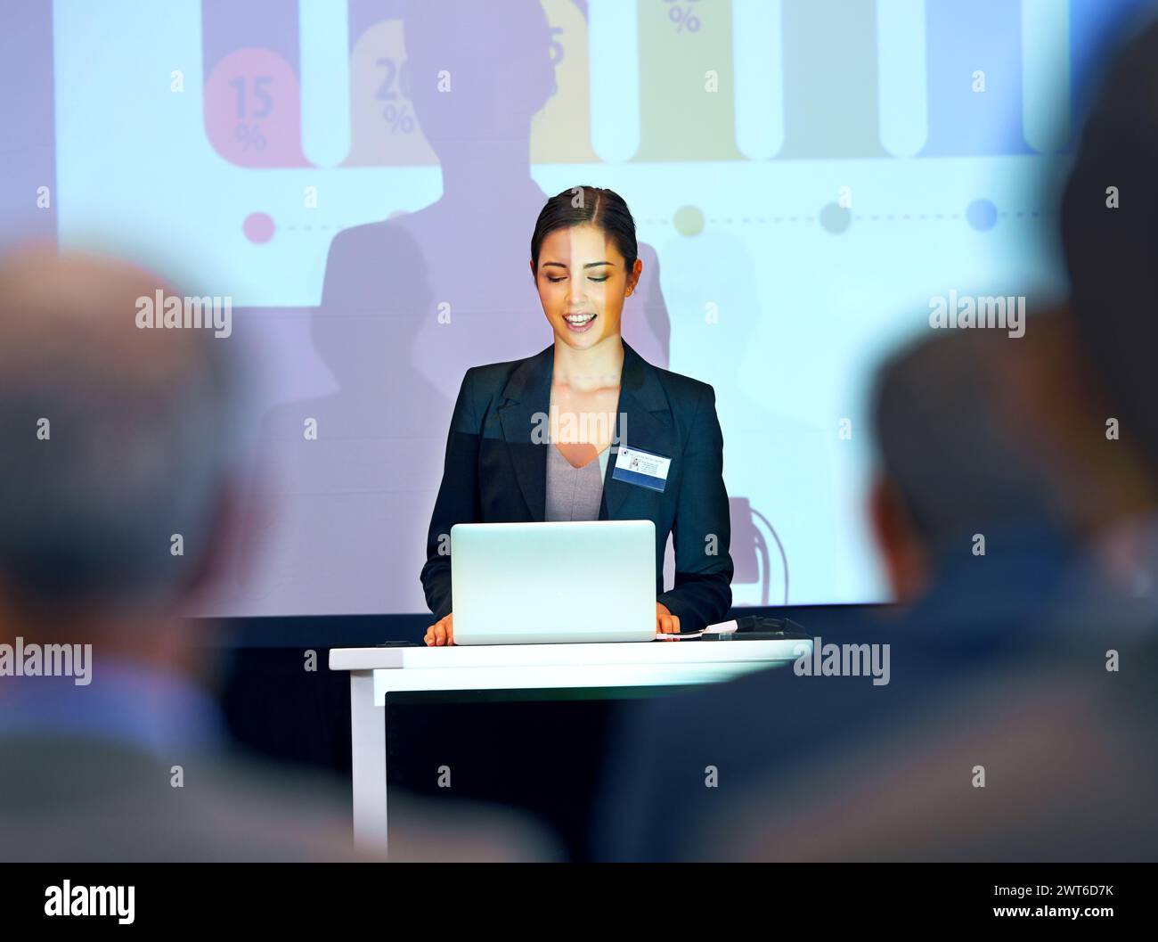 Business woman, podium and presentation with projector screen, conference or workshop with laptop for slideshow. Corporate training, seminar and Stock Photo