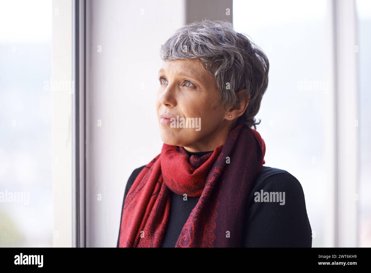 Thinking, nostalgia and mature woman in window with memory, moment and reflection in home. Remember, face and elderly female in living room for Stock Photo