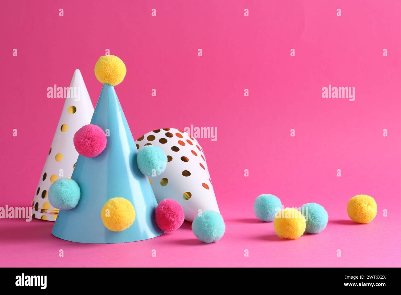 Party hats with color pompoms on pink background Stock Photo - Alamy