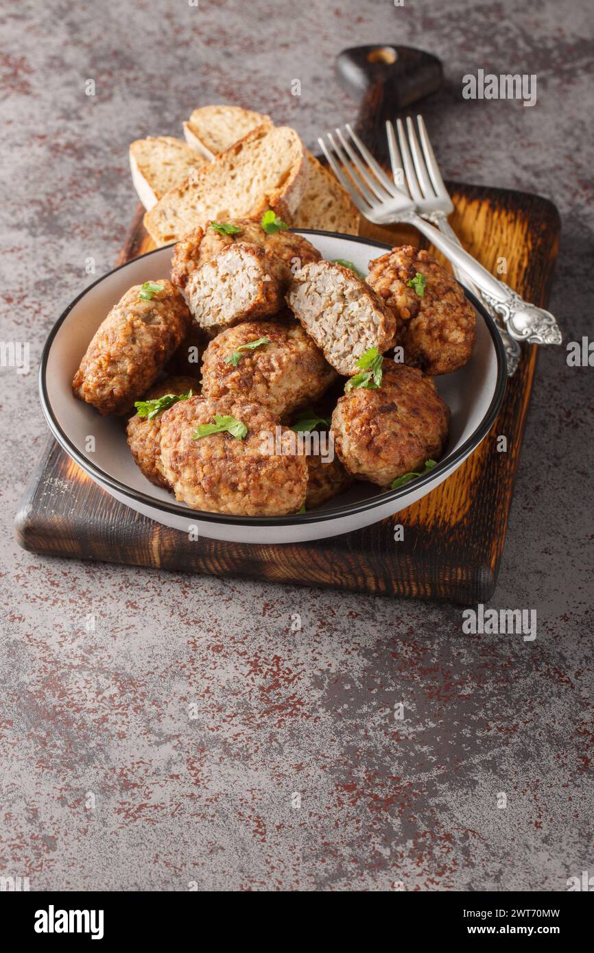 Buckwheat meatballs from minced meat and boiled buckwheat porridge with onions, spices close-up in a plate on the table. Vertical Stock Photo