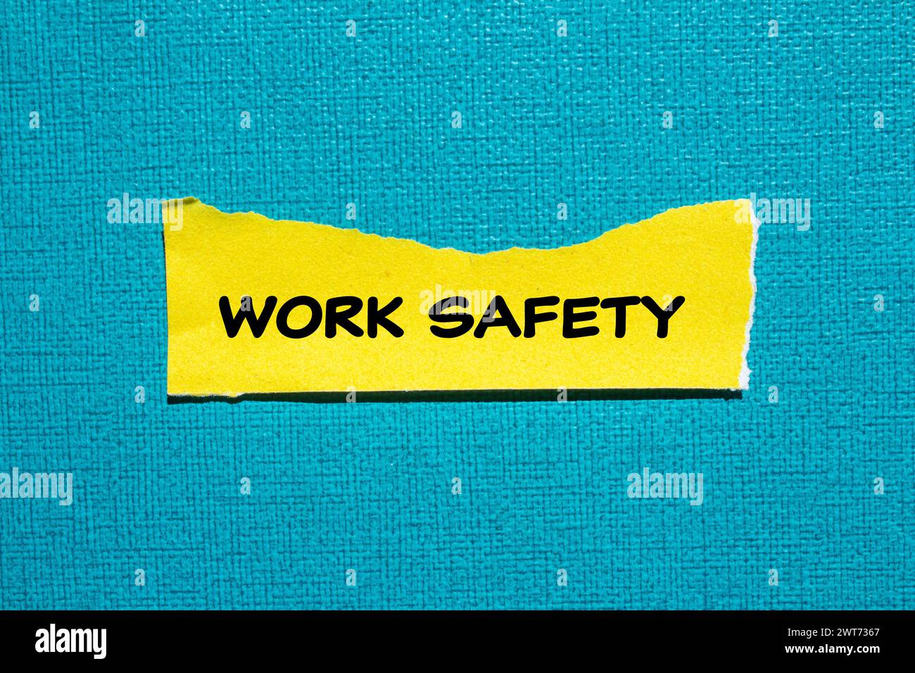 Work safety words written on yellow torn paper piece with blue background. Conceptual symbol. Copy space. Stock Photo