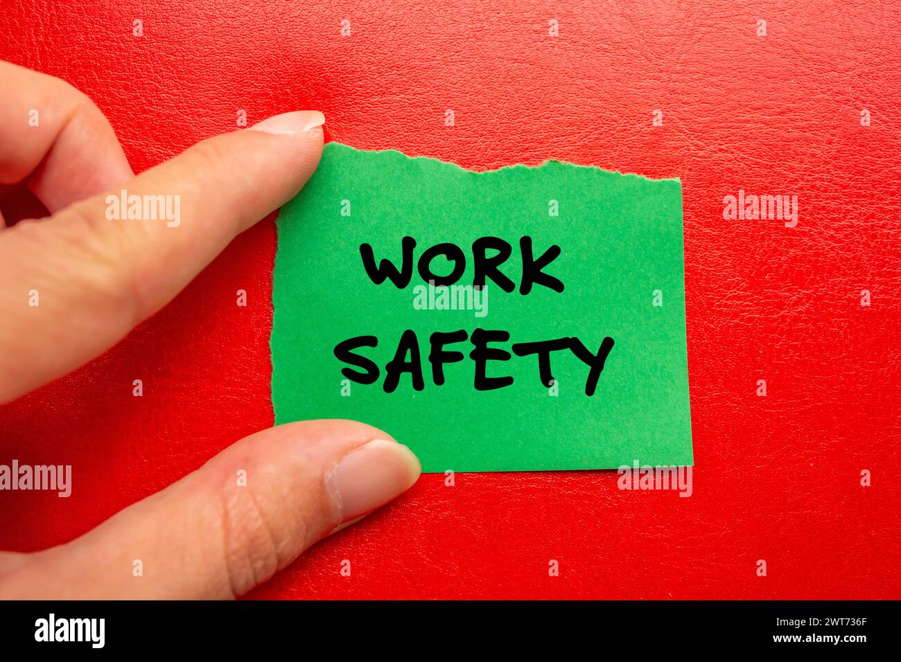 Work safety words written on green torn paper piece with red background. Conceptual symbol. Copy space. Stock Photo