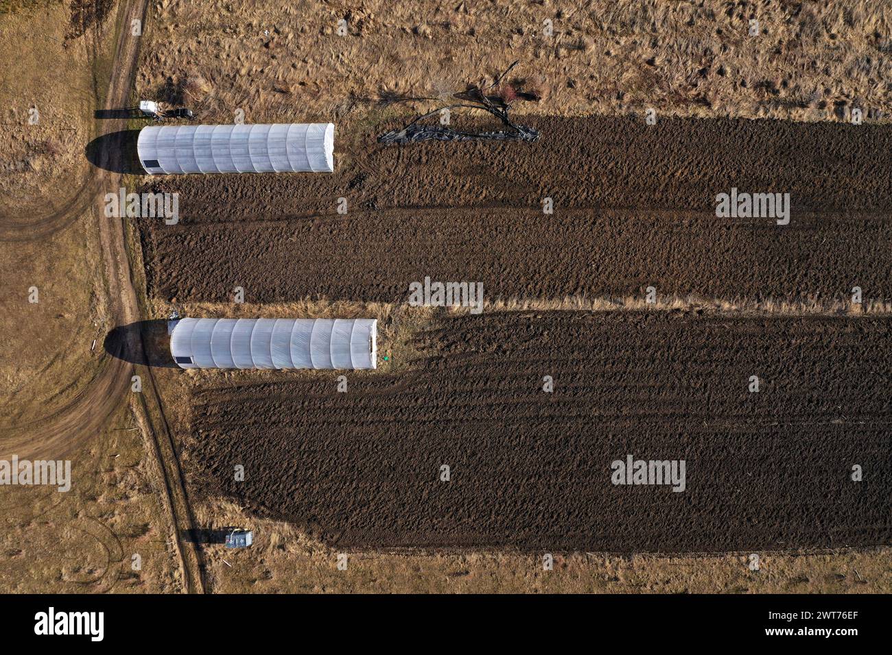 Aerial view of countryside greenhouse, farm, agricultural field in the spring by drone Stock Photo