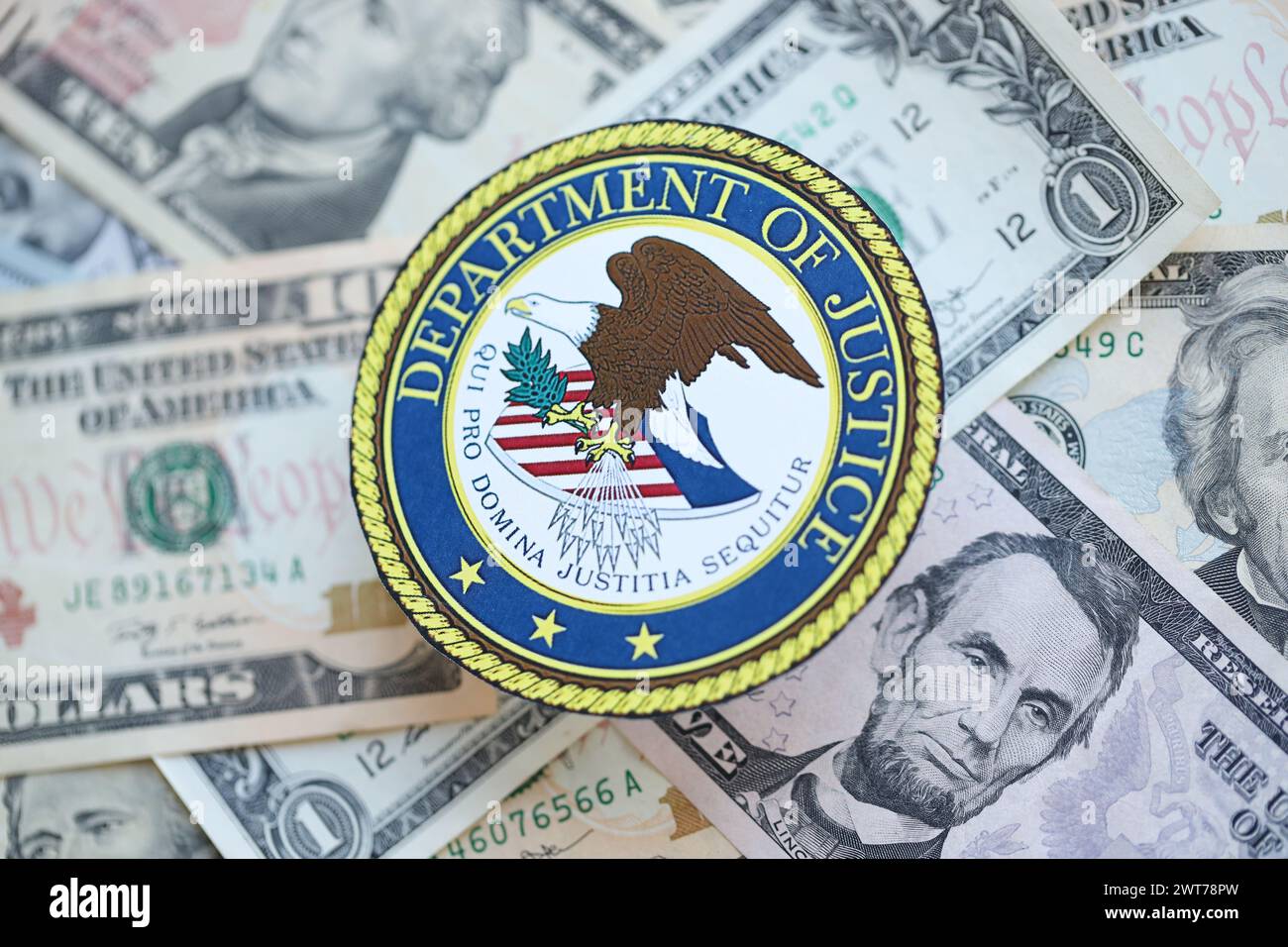 KYIV, UKRAINE - MARCH 9, 2024 US Department of Justice seal on many US dollar bills close up Stock Photo