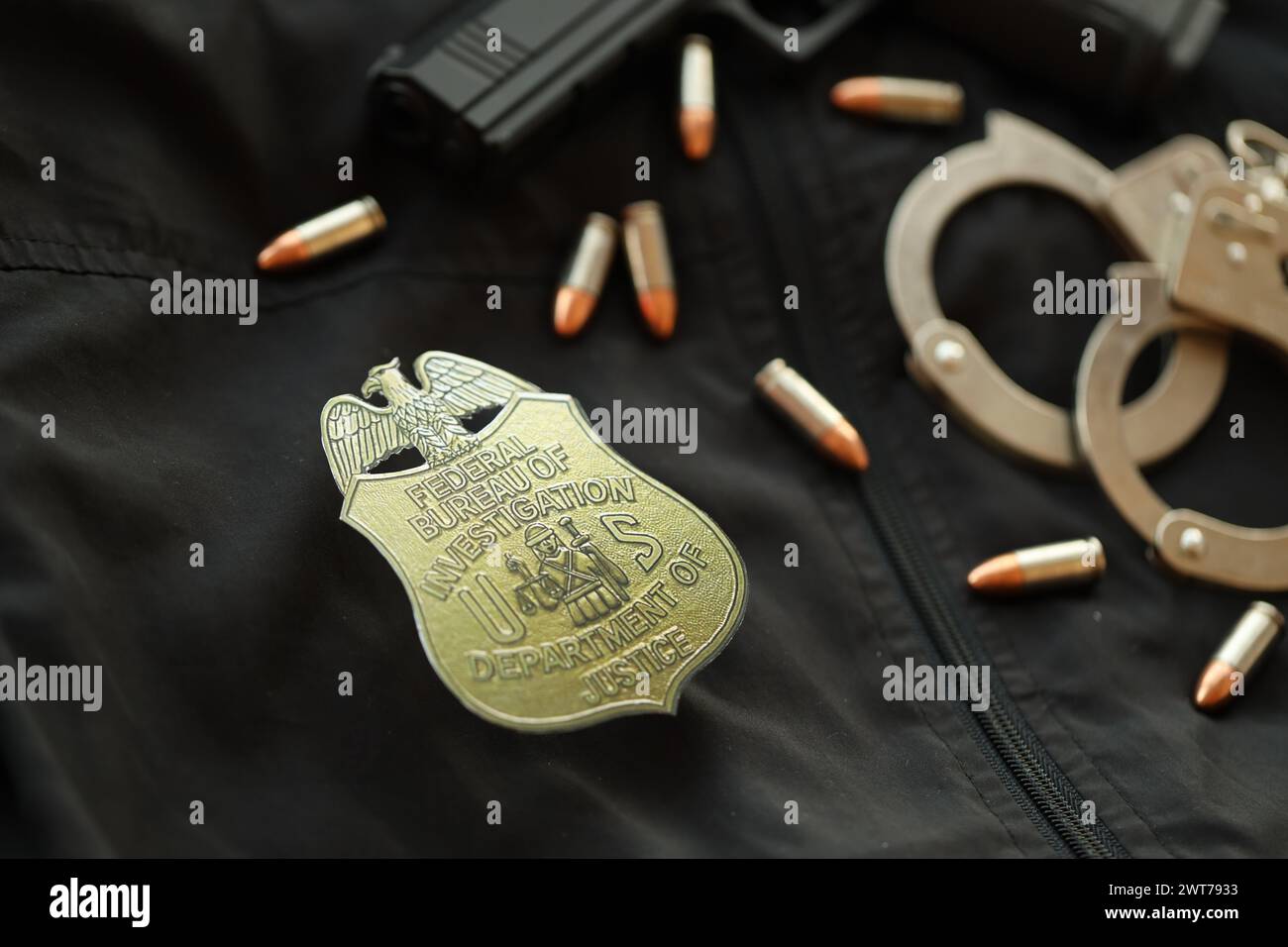 KYIV, UKRAINE - MARCH 9, 2024 US FBI Federal Bureau of Investigation badge on black jacket uniform with gun, bullets and handcuffs close up Stock Photo