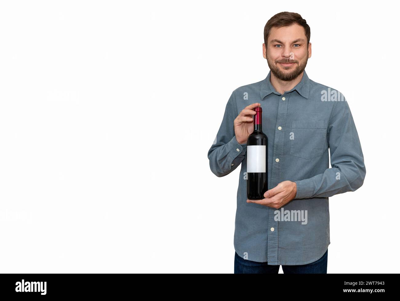 Isolated man customer of liquor store holds wine bottle in his hands and smiles. Stock Photo