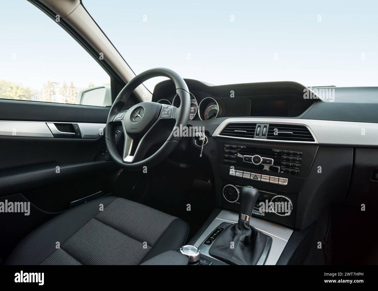 interior of 2010s Mercedes-Benz C-class interior. Dark grey seats, dashboard with aluminium trim elements. Stock Photo