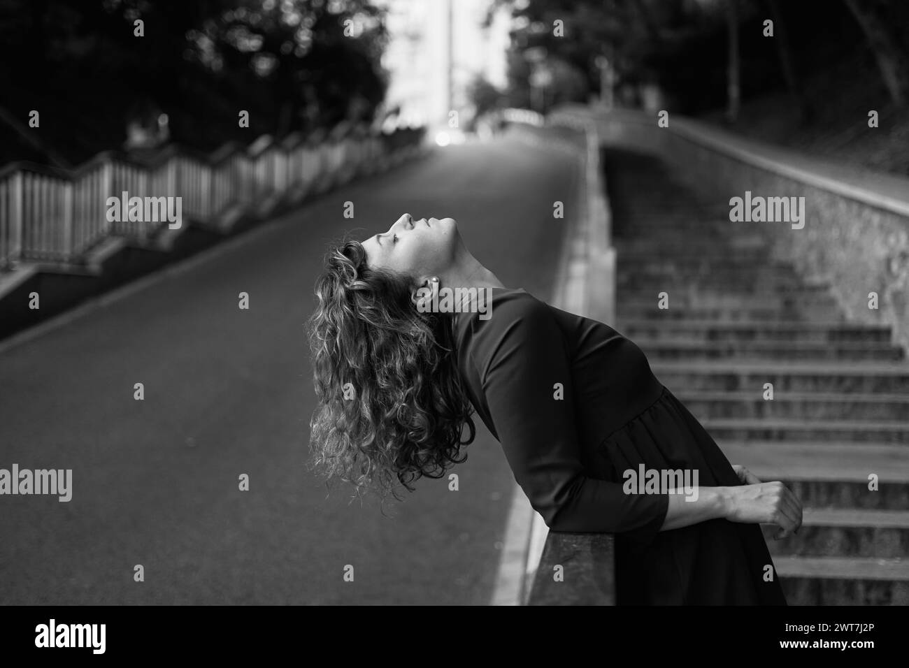 Cropped closeup portrait of a caucasian mature beautiful woman wife looking at the sun in park outdoors streets hiding from the sunset sun in sad serious mood. High quality photo Stock Photo