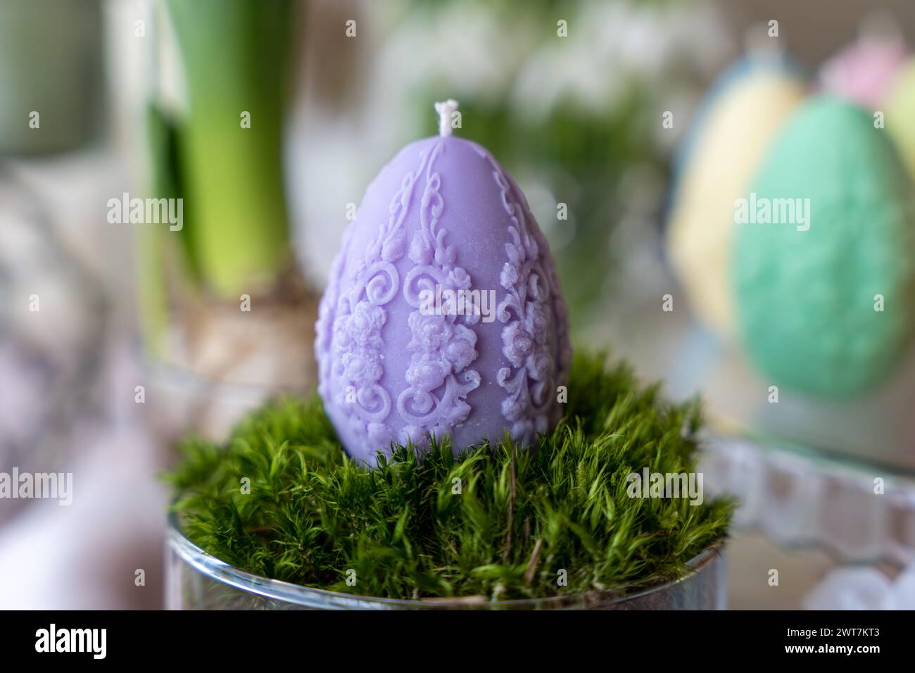 Colorful easter egg soy wax candle. Spring background Stock Photo
