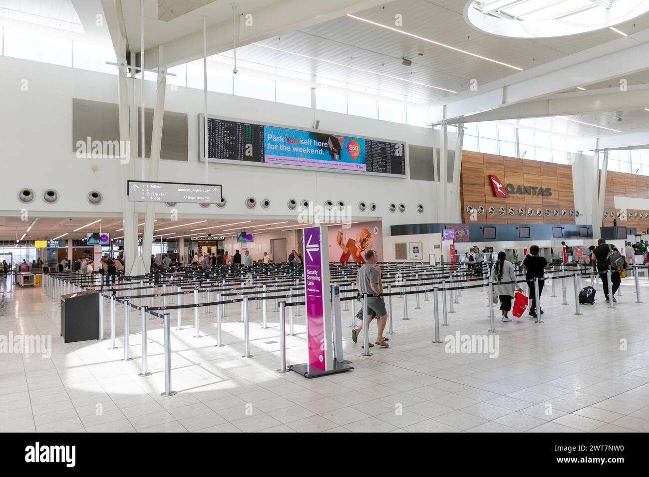 Adelaide airport departure hall in domestic terminal building, Qantas desk and passengers heading to security check,South Australia Stock Photo