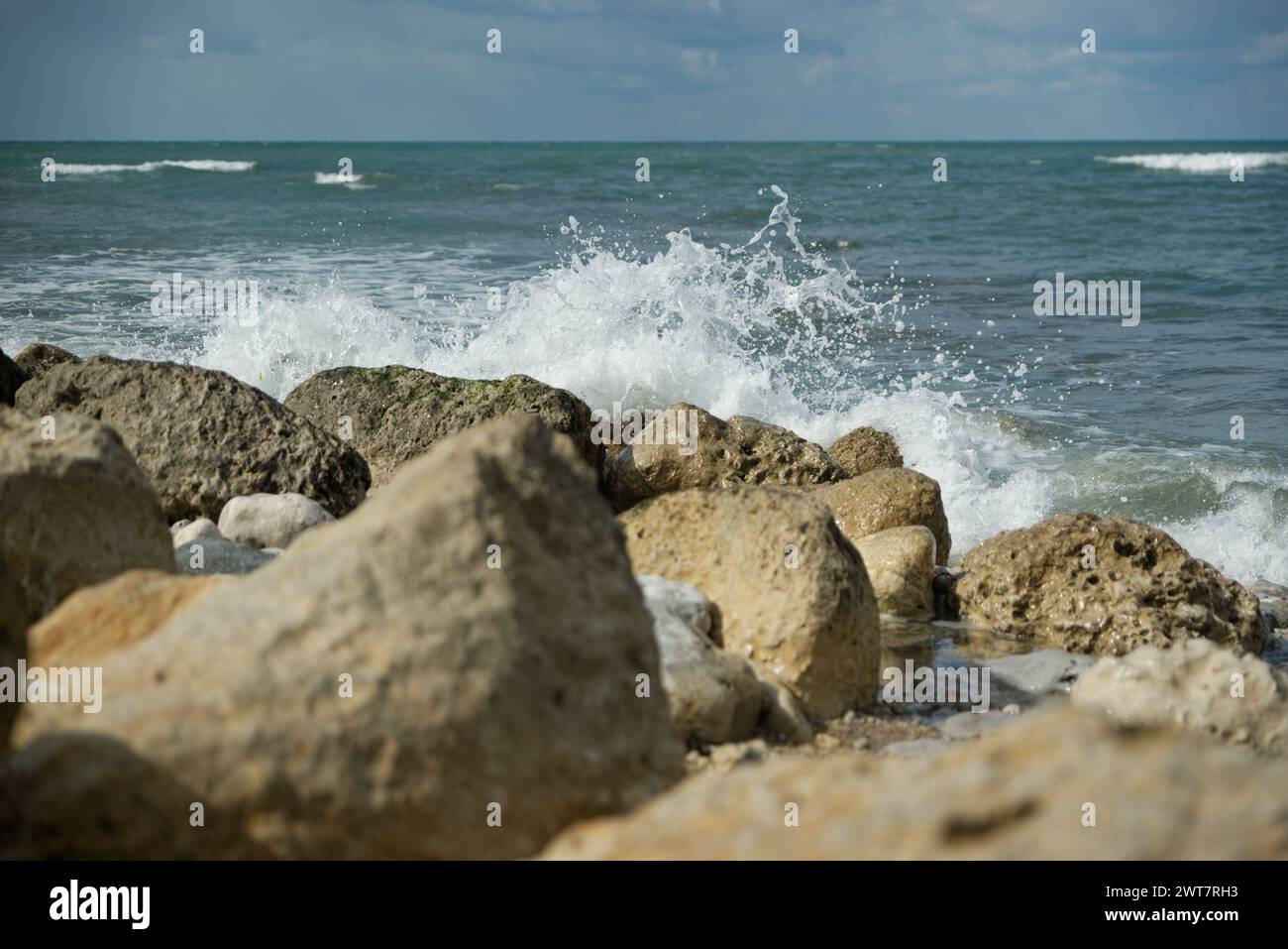 Waves splashing on rocks by the sea Stock Photo - Alamy