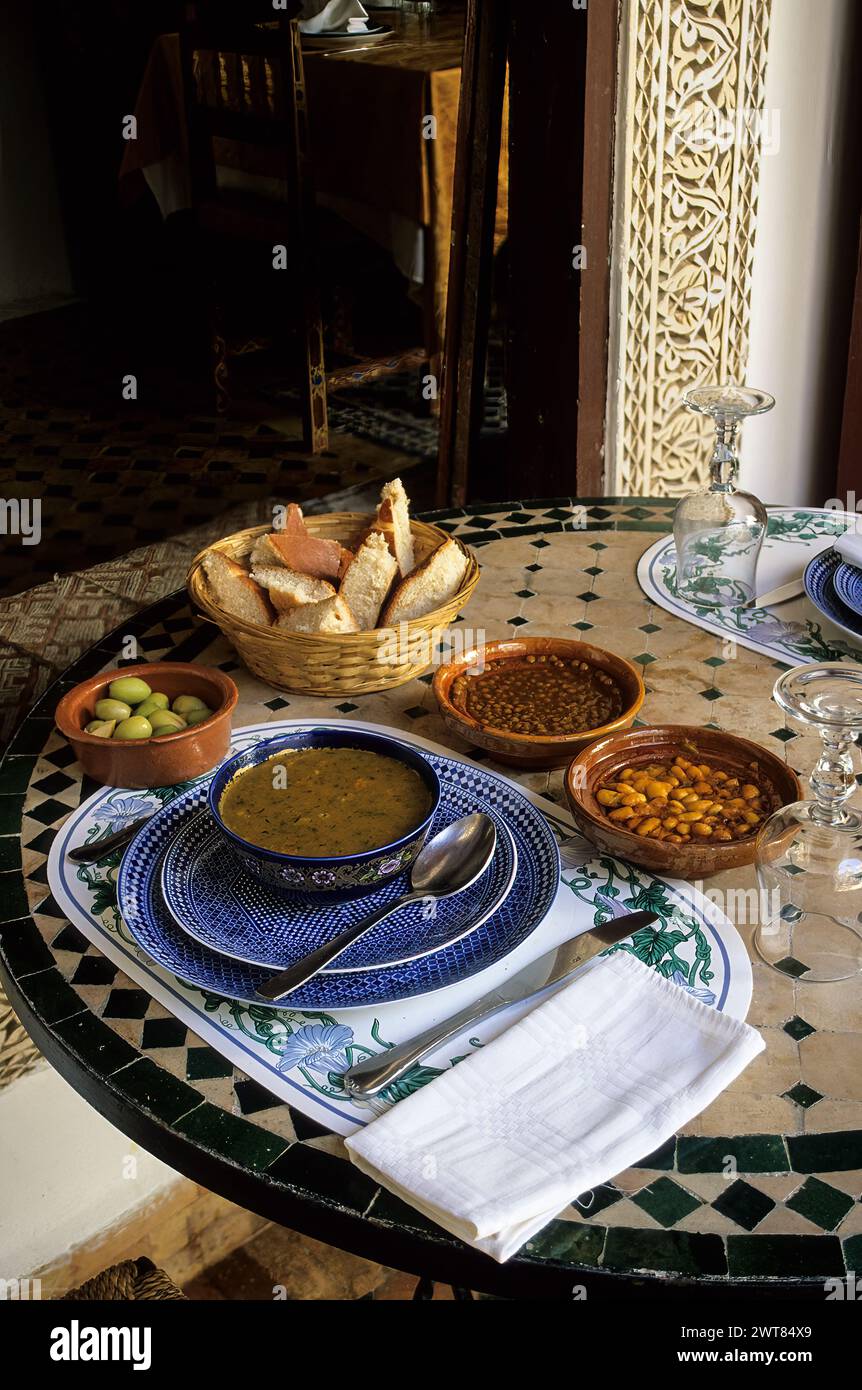 Meknes, Morocco.  A Moroccan Lunch:  harira, lentils, beans, olives, tomatoes, chickpeas, corriander, spices, bread Stock Photo