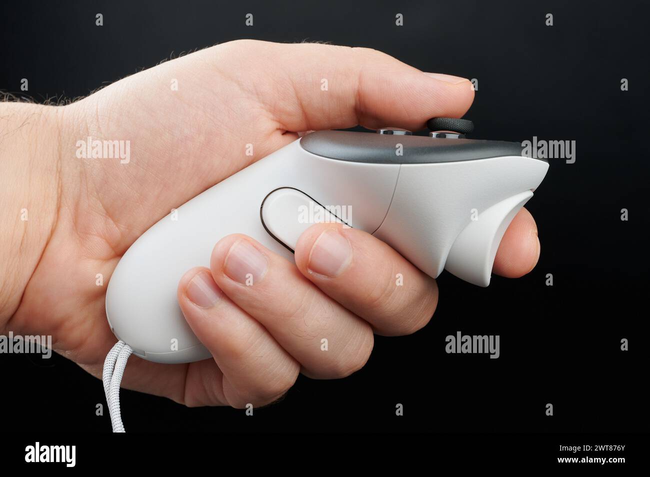 Hand hold VR joystick side view isolated on black studio background Stock Photo