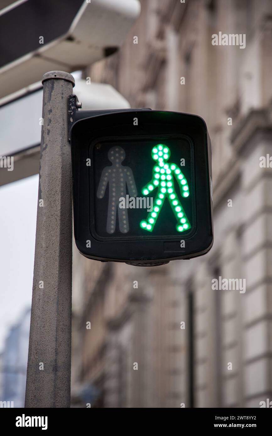 Pedestrian green light on a traffic light, abiding by the French and European traffic regulations, letting walking people crossing a crosswalk and a s Stock Photo