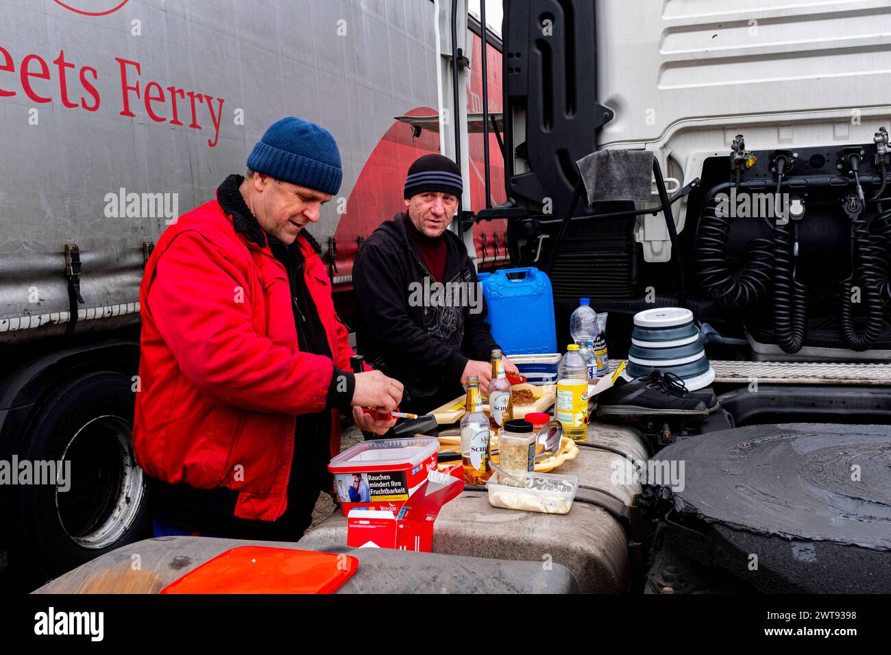 Truck Drivers & Freight Movers Rotterdam, Netherlands. Two Ukranian Truck Drivers camping out near their parked trucks at Mewehaven during a sunday afternoon. No facilities are avaiable to shower, toilet and cook and prepare food. Shops are miles away. Rotterdam M4H Stadshaven Zuid-Holland Nederland Copyright: xGuidoxKoppesx Stock Photo
