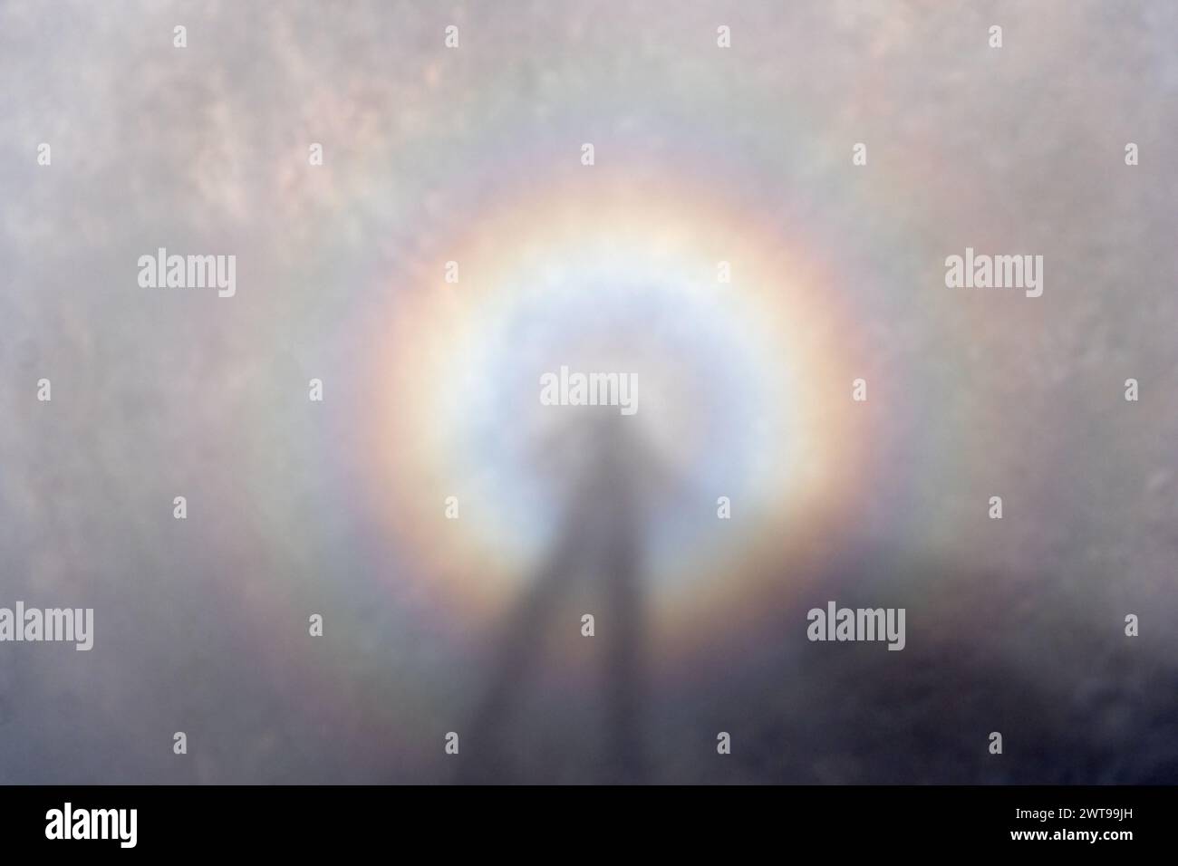 brocken spectre or specter formed when standing on a peak in a cloud with the sun behind you Stock Photo