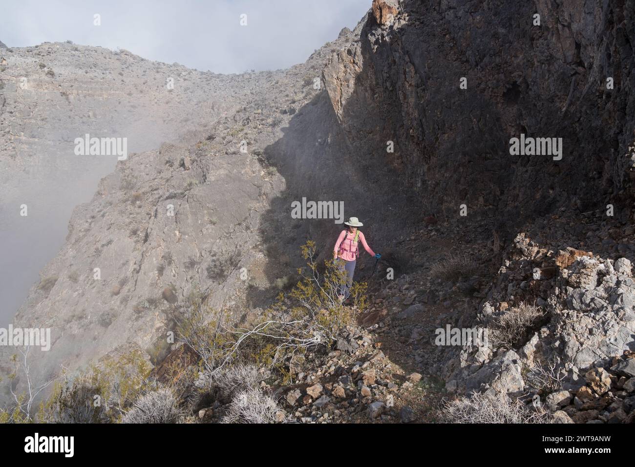 woman hiker in the Arrow Canyon Range of Nevada hiking up above the clouds Stock Photo