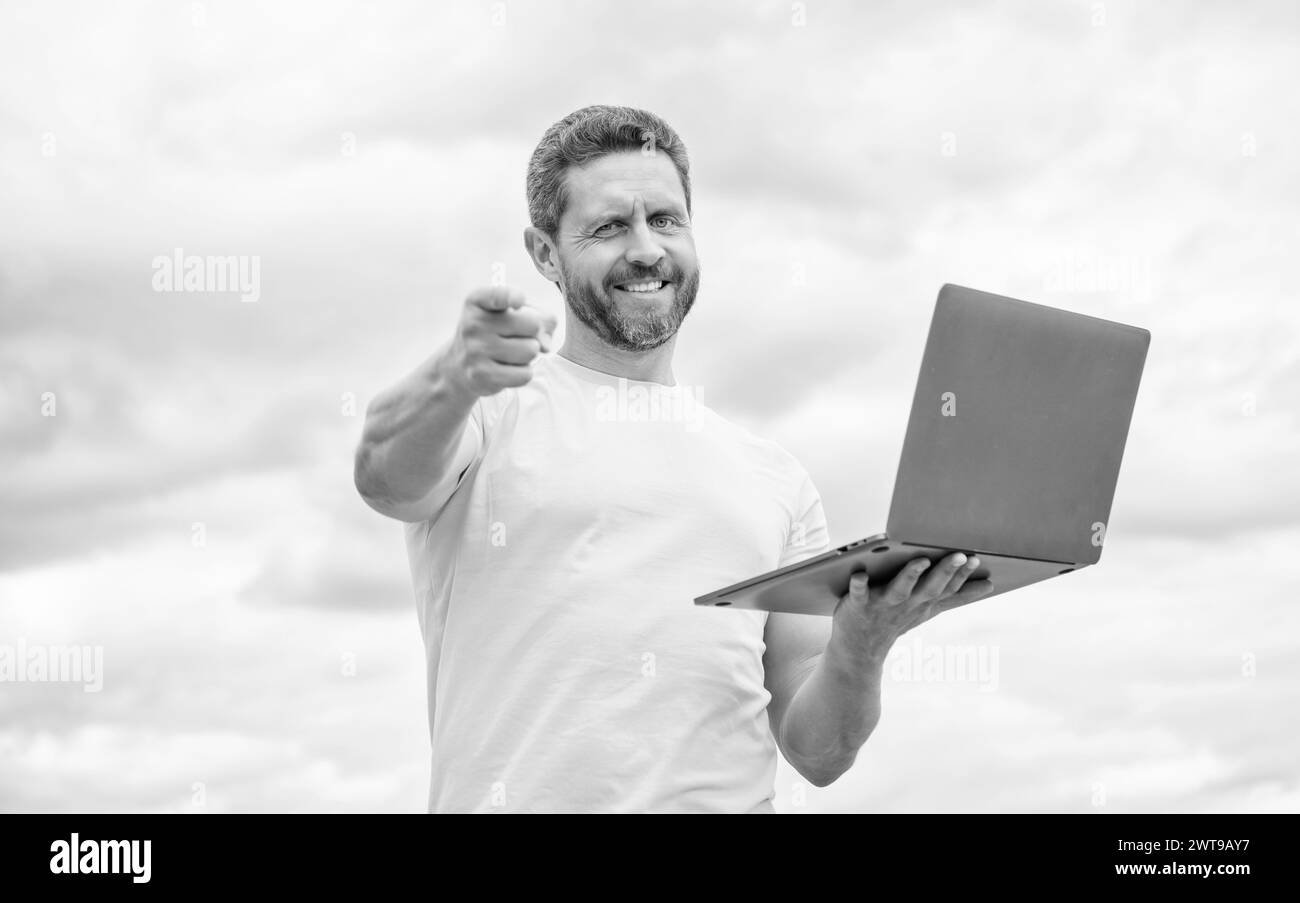 Positive man working online on laptop on sky background stock photo alamy