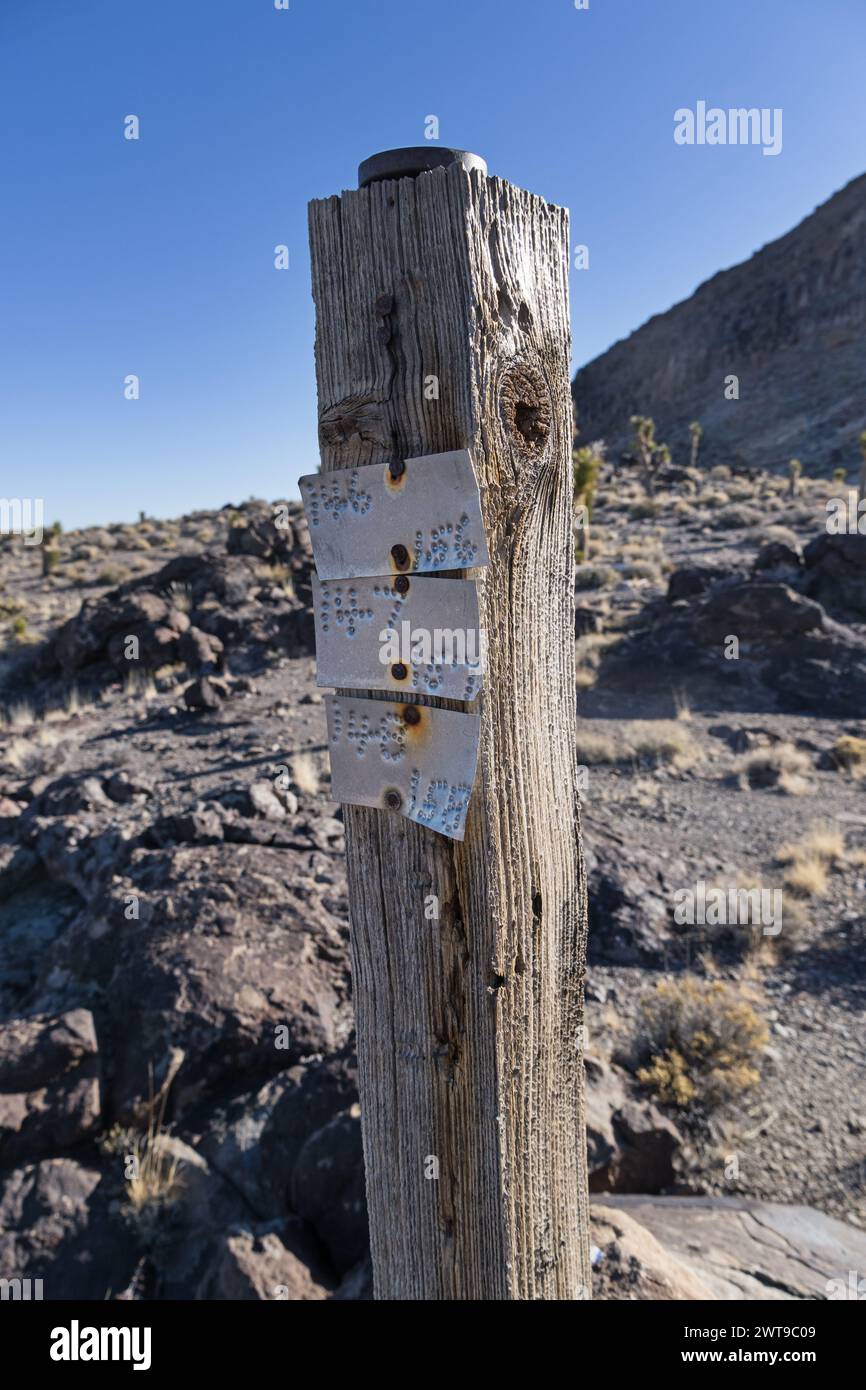 old aluminum mining claim marker signs on an old wooden post in the Nevada desert Stock Photo