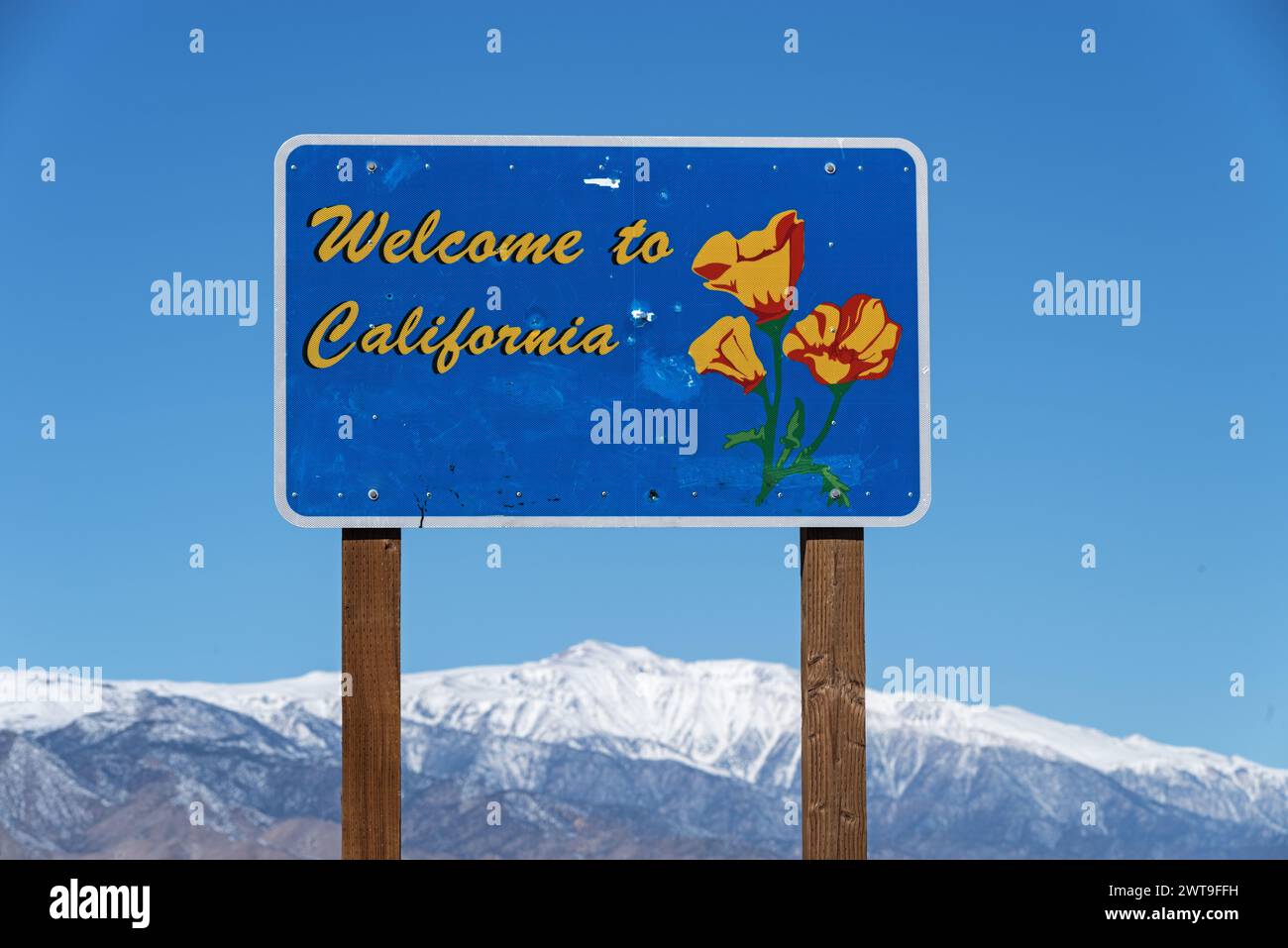 Welcome to California road sign along highway 266 at the Nevada Border with a snowy out of focus White Mountain in the distance Stock Photo