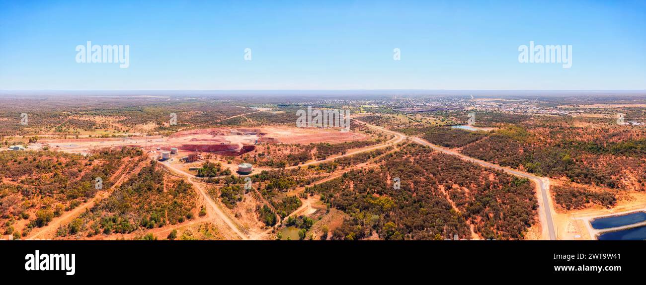 Plains of red soil Australian outback around Cobar mining town with copper open pit mine - aerial panorama. Stock Photo