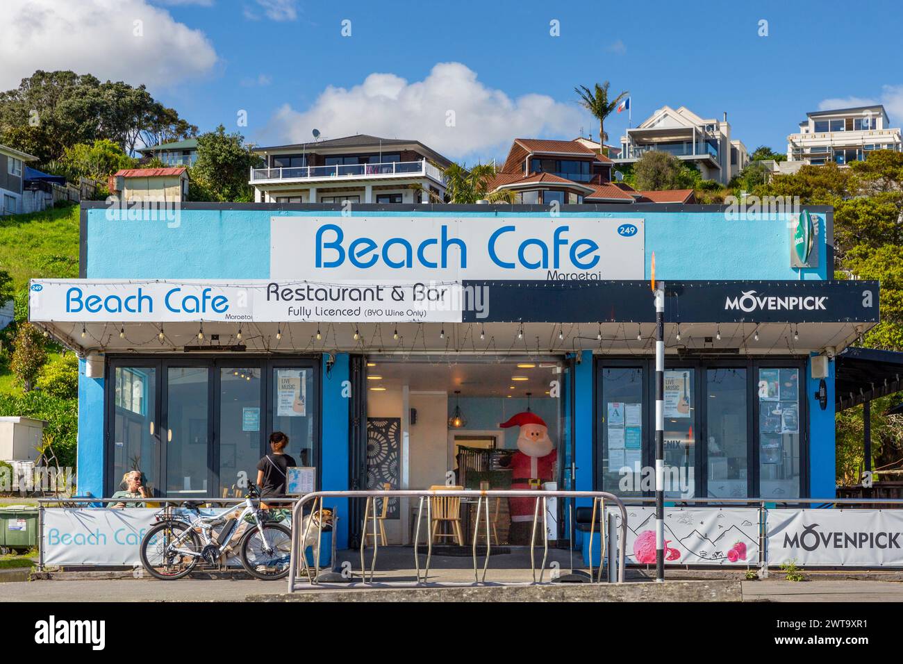 The Beach Cafe and hillside homes overlooking Tāmaki Strait at Maraetai, Tāmaki Makaurau / Auckland Region, Aotearoa / New Zealand. Stock Photo