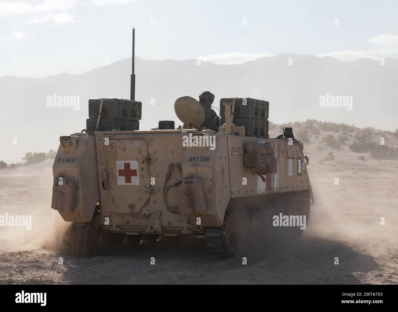 U.S. Soldiers in an M113 Armored Personnel Carrier rush back to the pickup area after transporting casualties during a medical experiment at Fort Irwin, Calif., March 14, 2024, for Project Convergence - Capstone 4. During the exercise, Soldiers conducted initial trauma care to incoming patients while testing new technology like new patient treatment systems; the Health Readiness and Performance System, which monitors a Soldier's health while using tracking applications; and new training aids. (U.S. Army photo by Sgt. Charlie Duke) Stock Photo