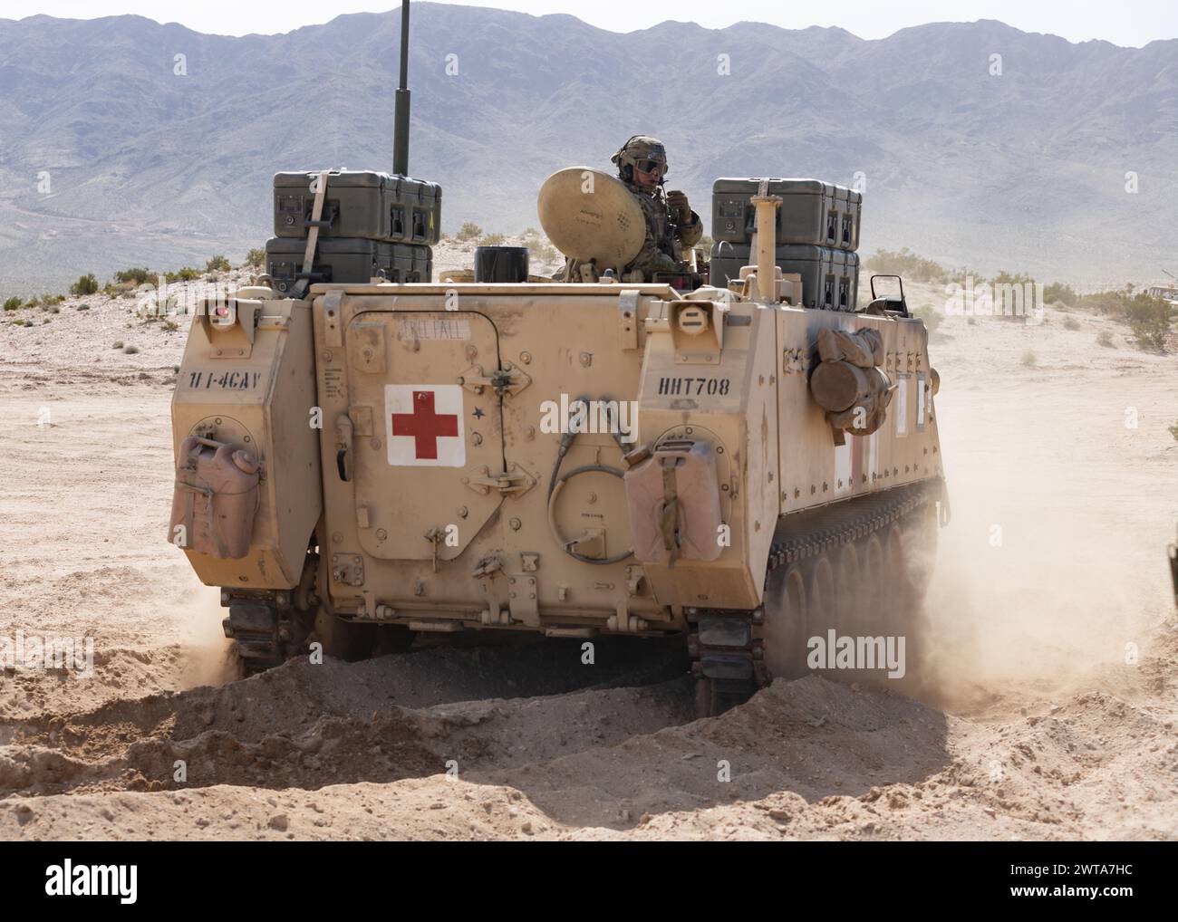 U.S. Army Soldiers assigned to the 1st Infantry Division deliver simulated patients in an M113 armored personnel carrier for triage during ongoing experimentation of new medical capabilities during Project Convergence – Capstone 4 in Fort Irwin, Calif., March 14, 2024. The experiments bring new technology that can conduct initial trauma care to incoming patients and provide advanced trauma management and surgery in an operational environment.     PC-C4 is an U.S. Army-hosted Joint and Multinational experiment integrating modernization capabilities and formations through persistent experimentat Stock Photo