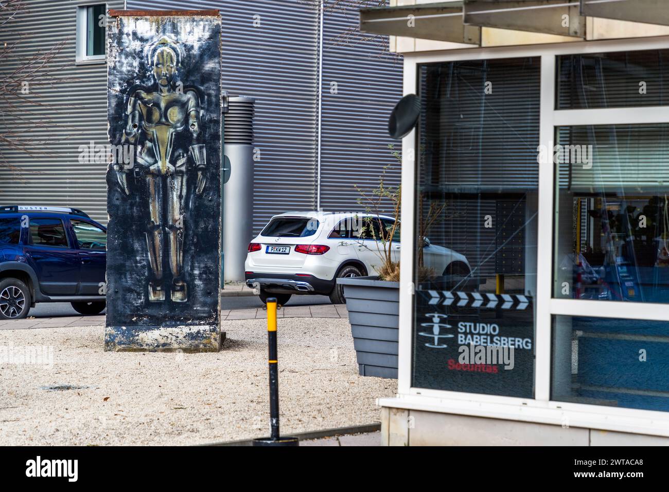 A section of the Berlin Wall with the machine man Maria from the monumental silent film Metropolis from 1927. Entrance and driveway to the Studio Babelsberg production site, August-Bebel-Straße, Potsdam, Brandenburg, Brandenburg, Germany Stock Photo