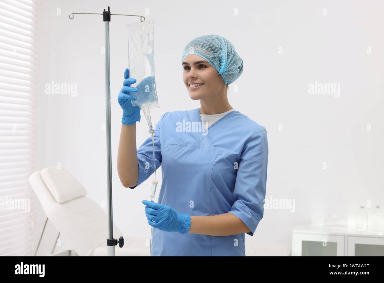 Nurse setting up IV drip in hospital Stock Photo