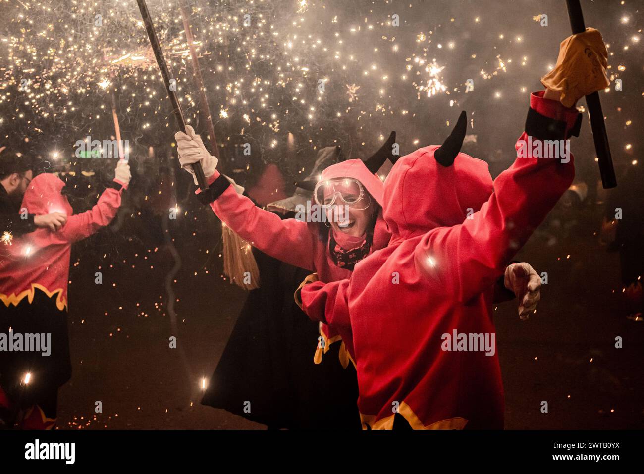 March 16, 2024, Barcelona, Spain. Women dressed as devils take part in a correfoc known in Catalan  as Dones de foc (Fire Women) and which is part of the activities of past International Women's Day (8M). In this correfoc, where feminism and women's rights are vindicated, only women participate as devils. Correfocs are an old Catalan tradition where people dress as devils and light firecrackers and flares. Credit: Jordi Boixareu/Alamy Live News Stock Photo