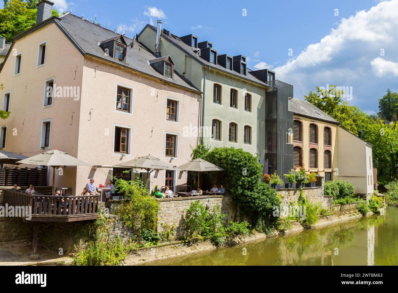 People enjoying the sun at a cafe in Grund, Luxembourg city Stock Photo