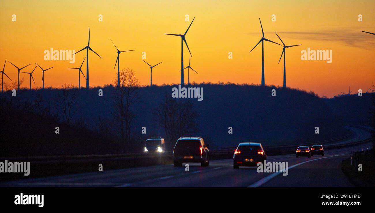 Wind turbines at sunrise with cars on the A 44 motorway, Bueren, Paderborn plateau, North Rhine-Westphalia, Germany Stock Photo