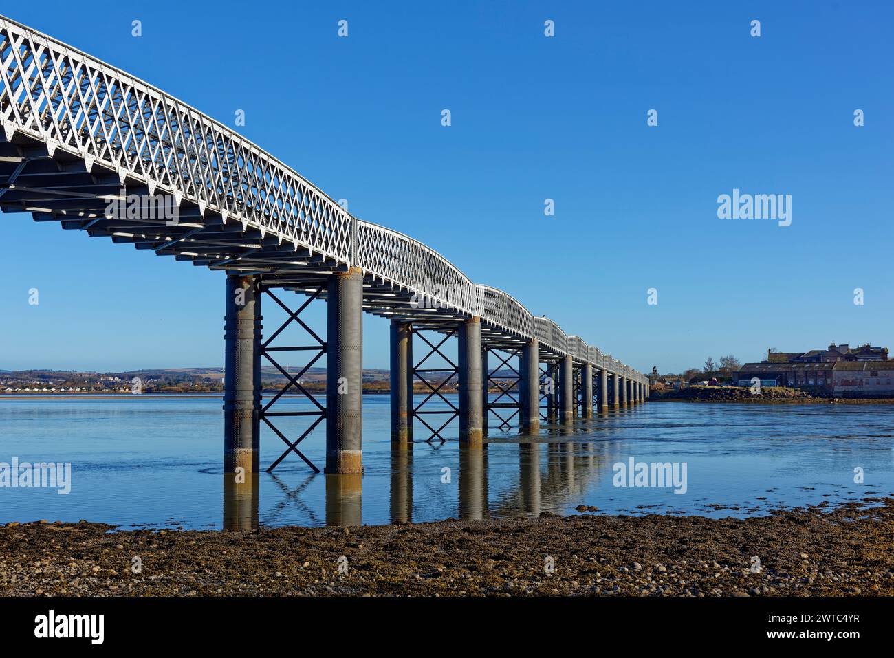 The South Esk Rail bridge crossing the South Esk River during the ebbing tide at the Montrose Basin on a bright morning in March. Stock Photo