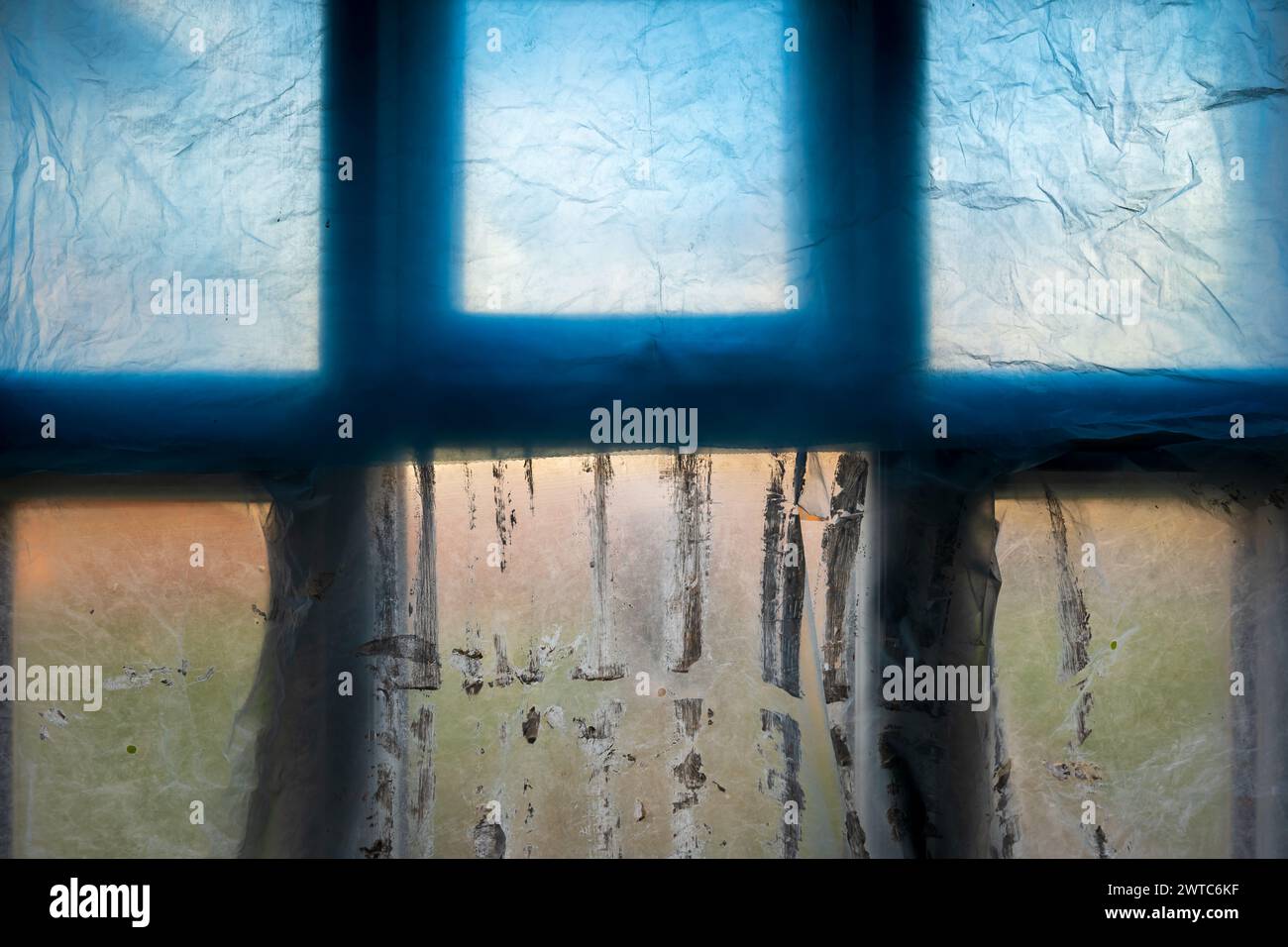 window covered with polyethylene during room paintins in england uk. Stock Photo