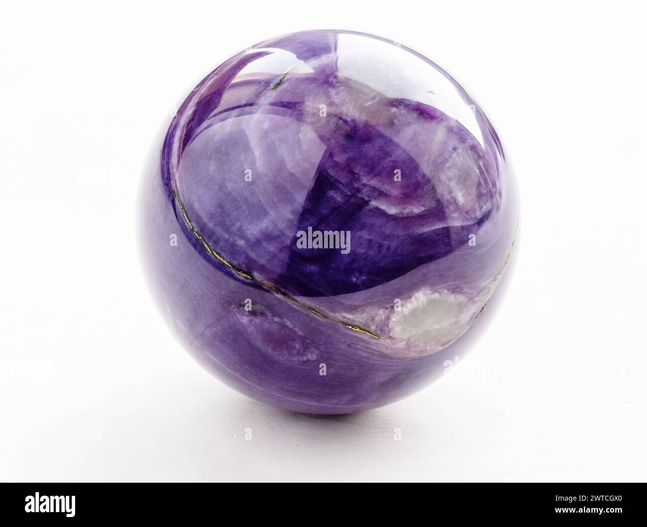 polished ball from natural charoite gemstone on white background from Sakha Republic, Siberia, Russia Stock Photo