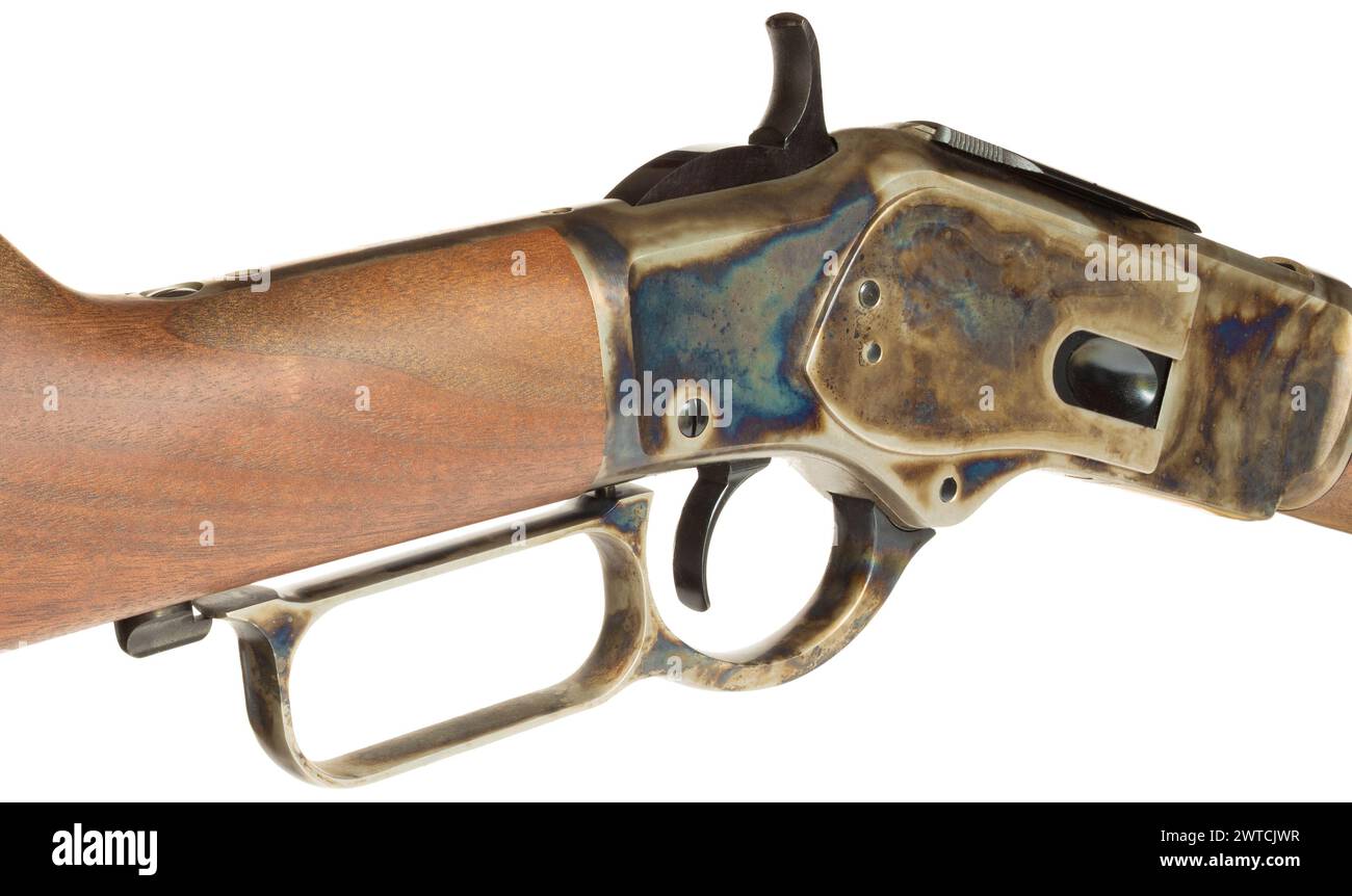 Isolated lever and receiver on a lever action rifle that are color casehardened on a wood stock. Stock Photo