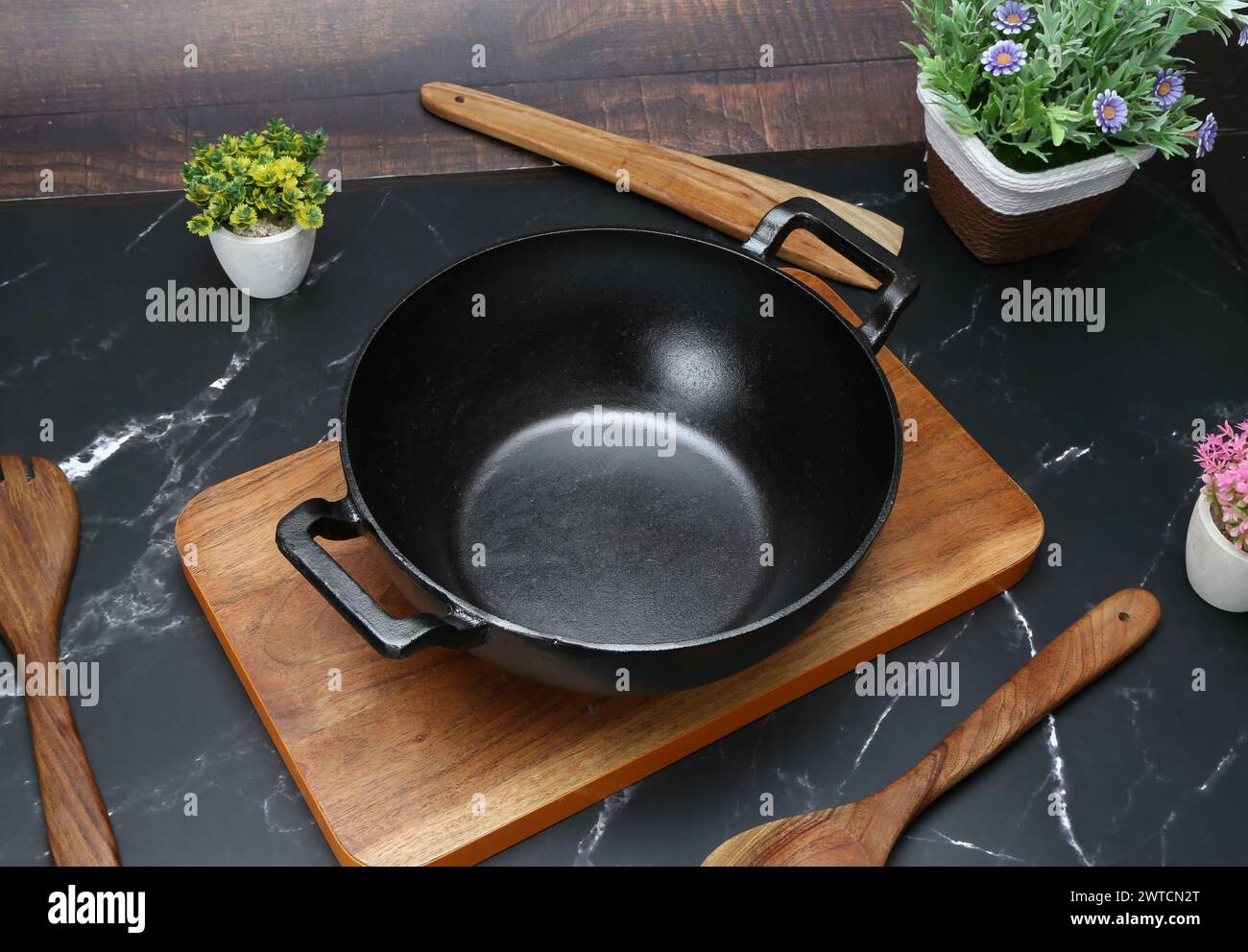 Black non stick deep Karahi on the wooden choping board Stock Photo