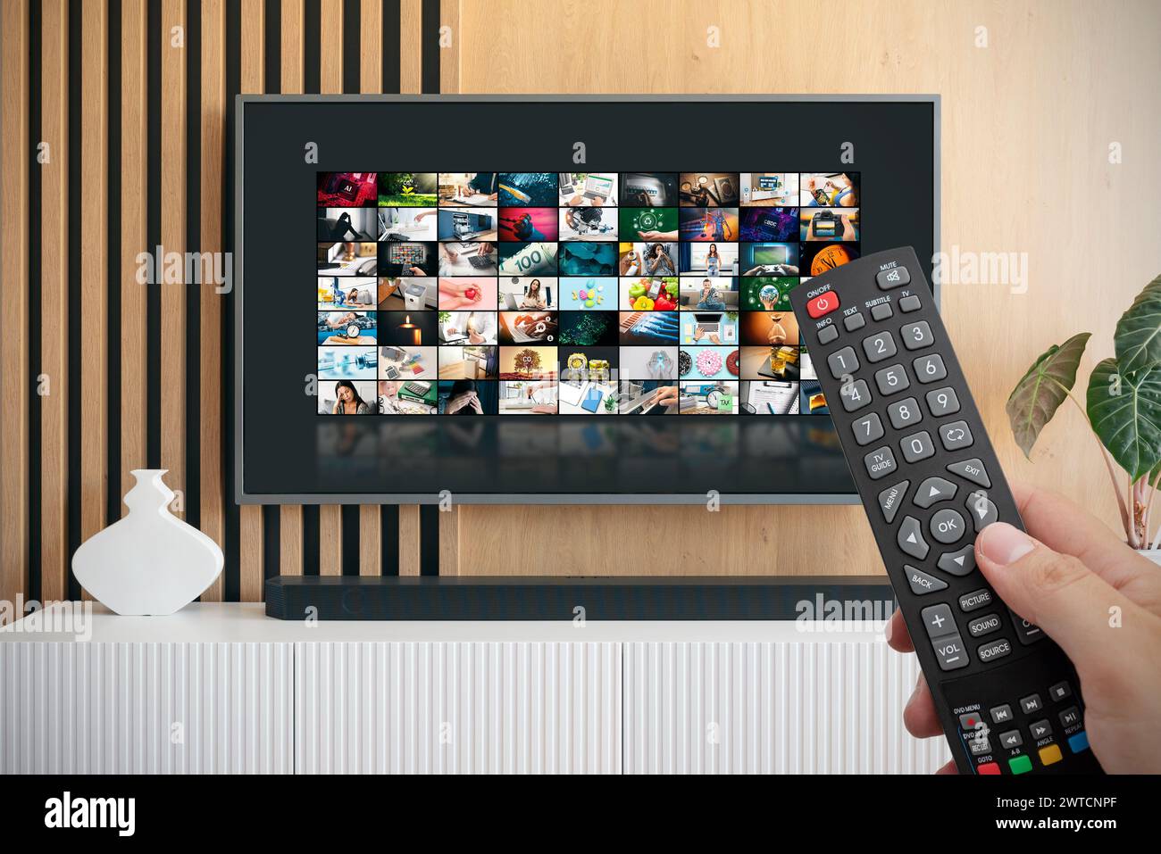 VOD service screen. Man watching TV with remote control in hand. Stock Photo