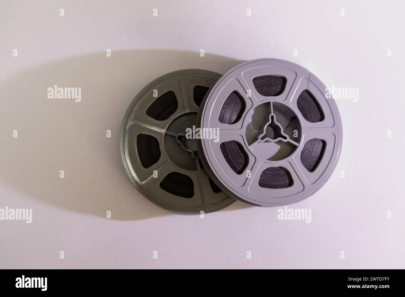 Selective focus, close up on two old school 8mm film reels against a white background with its shadow falling to the left side Stock Photo
