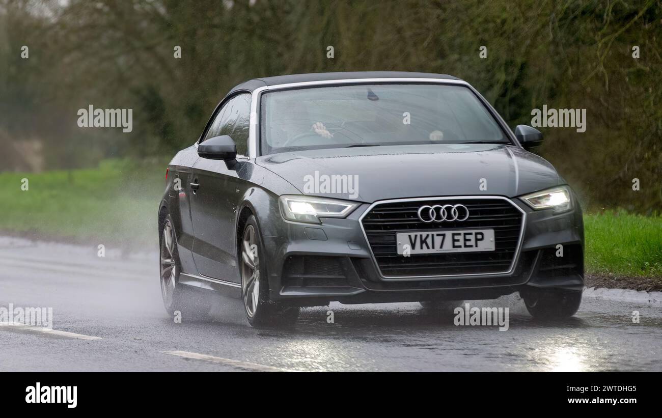 Milton Keynes,UK-Mar 17th 2024: 2017 grey diesel engine Audi A3 car driving in the rain Stock Photo