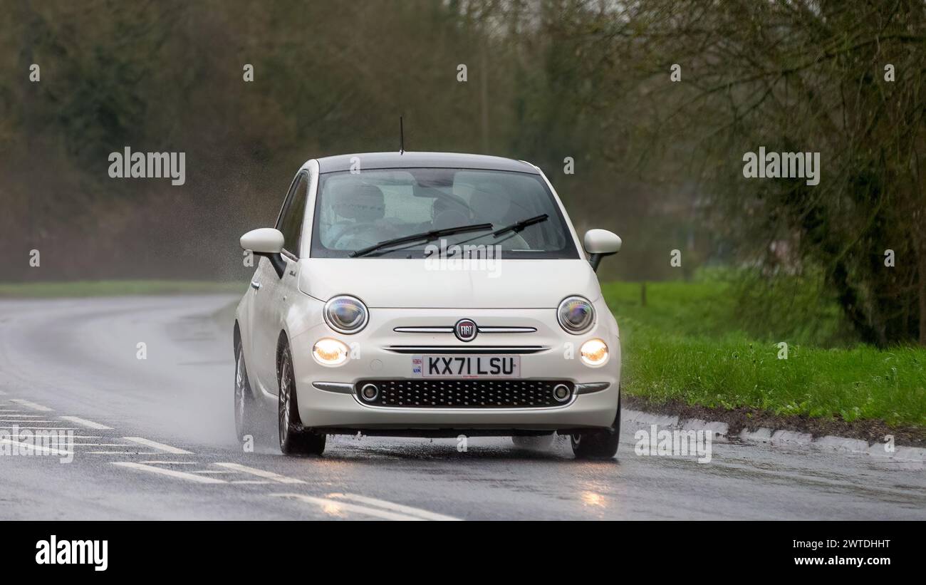 Milton Keynes,UK-Mar 17th 2024:  2021 white Fiat 500 Dolcevita car driving in the rain Stock Photo