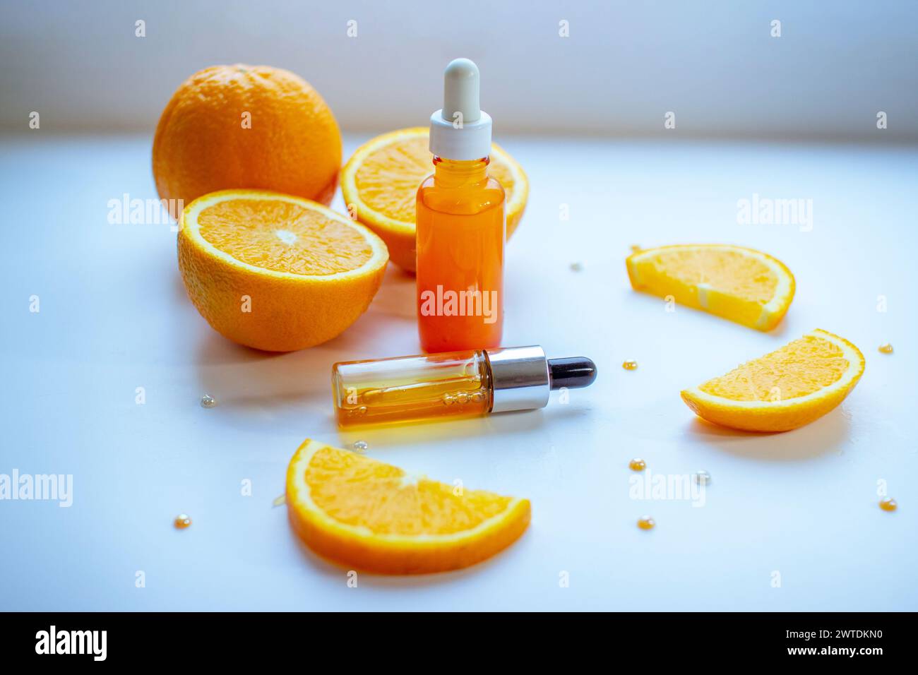 Vitamin C face skin care cosmetic concept - organic serum in a bottle and orange slices on white background Stock Photo