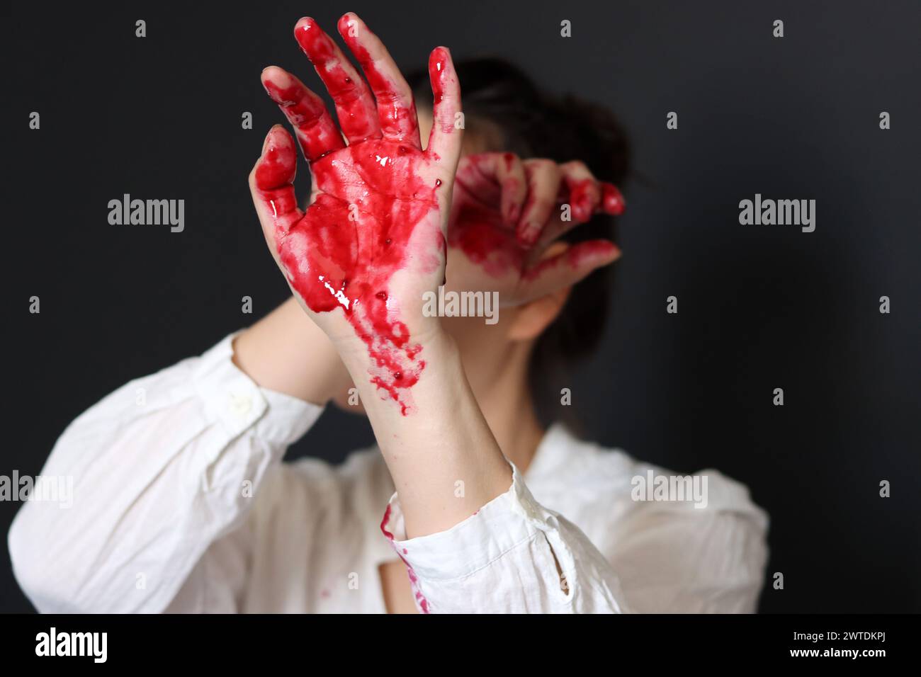 Female hands with blood on a black background with copy space. The concept of crime and domestic violence. Stock Photo