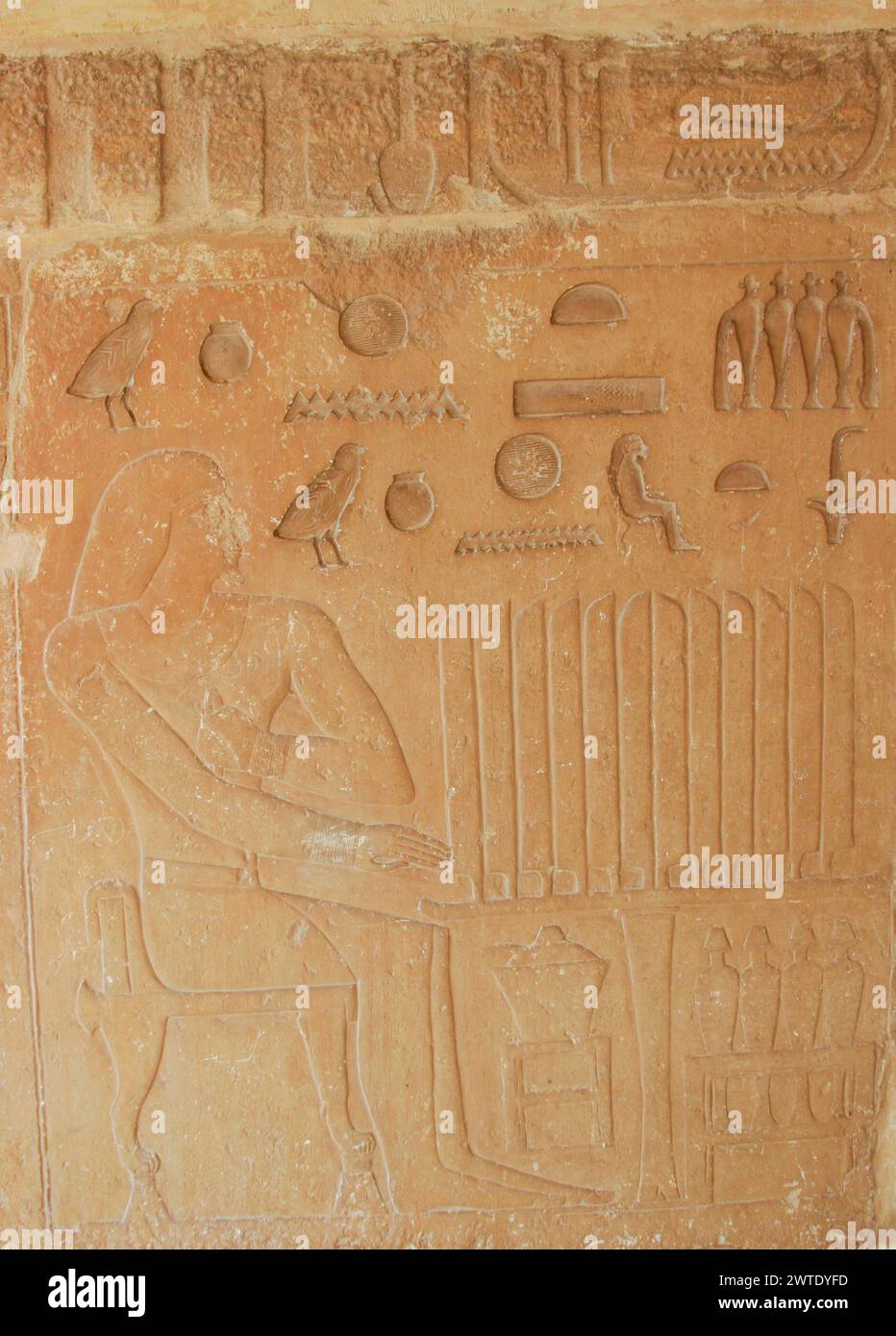 Egypt, Saqqara, near Unas causeway, ruins of the Khenu mastaba : Khenu seated in front of a table full of bread slices. Stock Photo