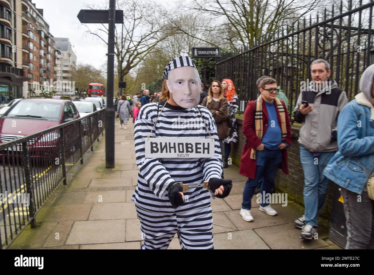 London, UK. 17th March 2024. A protester dressed as Putin in prison clothing and wearing handcuffs walks outside the Russian Embassy in London while Russian citizens queue to cast their vote, as elections take place in Russia. Credit: Vuk Valcic/Alamy Live News Stock Photo