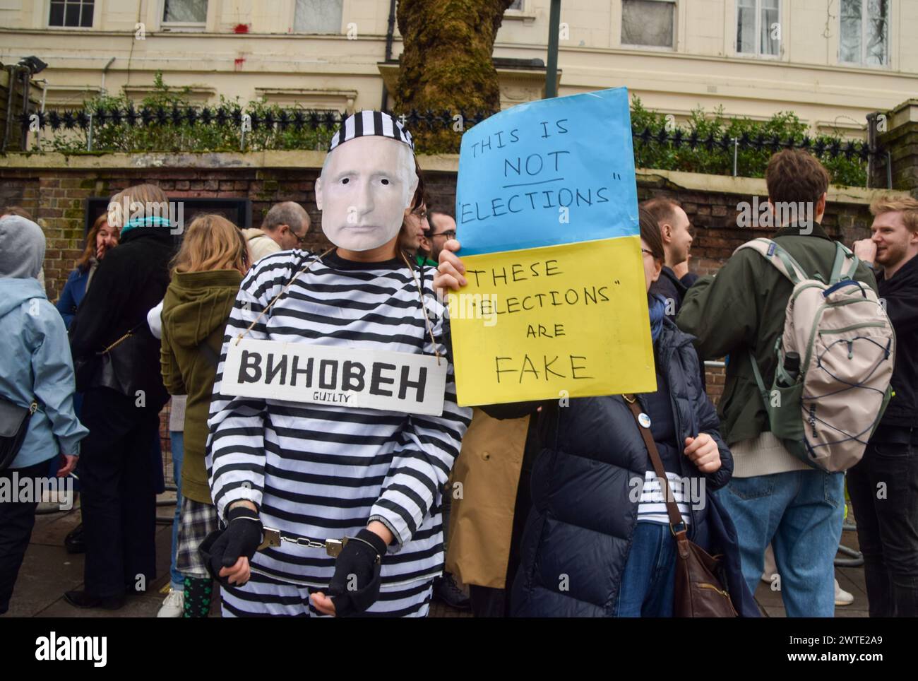 London, UK. 17th March 2024. A protester dressed as Putin in prison clothing and wearing handcuffs stands outside the Russian Embassy in London while Russian citizens queue to cast their vote, as elections take place in Russia. Credit: Vuk Valcic/Alamy Live News Stock Photo