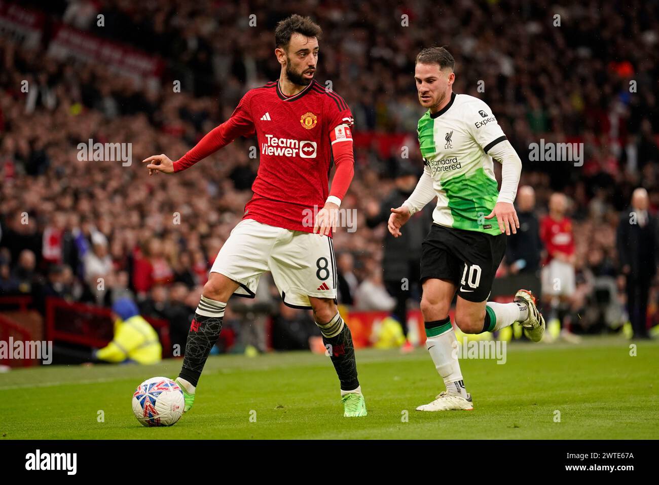 Manchester United's Bruno Fernandes, left, is challenged by Liverpool's