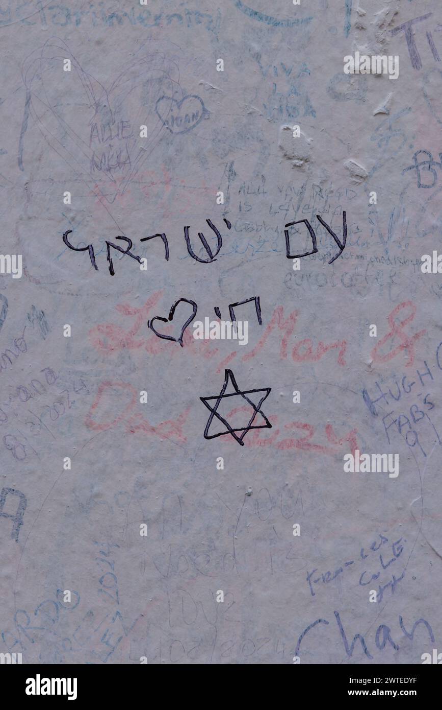 Abbey Road, London, UK. 17th March 2024. A group of Israeli High School students, survivors of the 7th October 2023 terrorist attack, who have been visiting London as part of a delegation organised by 7/10 Human Chain, write 'Am Israel Chai' ('The People of Israel Live') on the Abbey Road studio wall for their 7 friends and neighbours, still held captive in Gaza since being taken from their homes during Palestinian attack in Israel 163 days ago. The group have been visiting students in London to share their stories and horrific experiences of the massacre. Photo by Amanda Rose/Alamy Live News Stock Photo