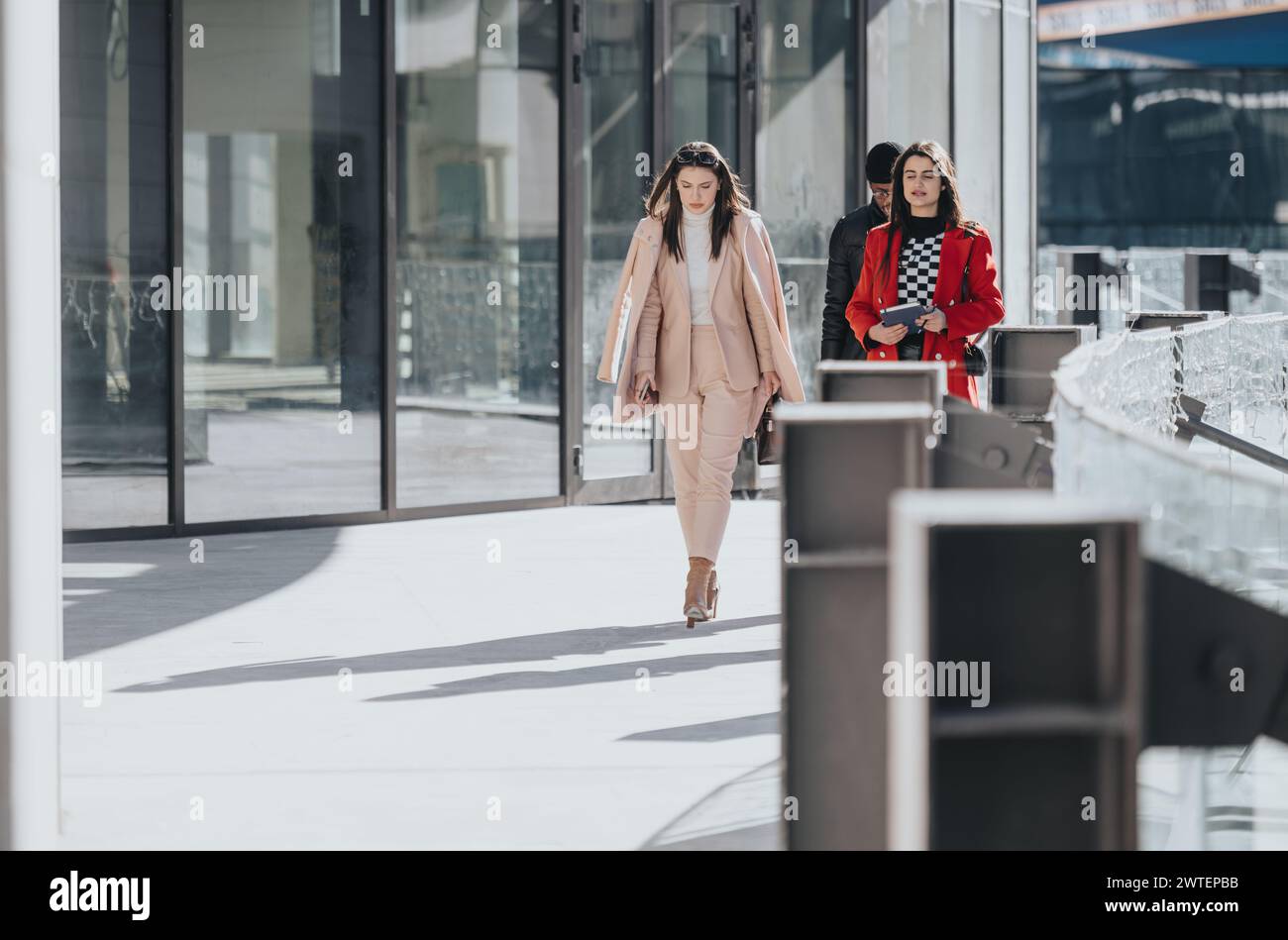 Two professional women and man walking side by side in a modern urban ...